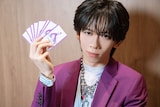 「RYOGA THE CARD」を手にするリョウガ（超特急）。