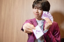 カードをこちらに差し出すリョウガ（超特急）。