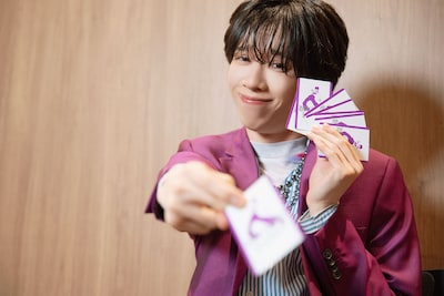 カードをこちらに差し出すリョウガ（超特急）。