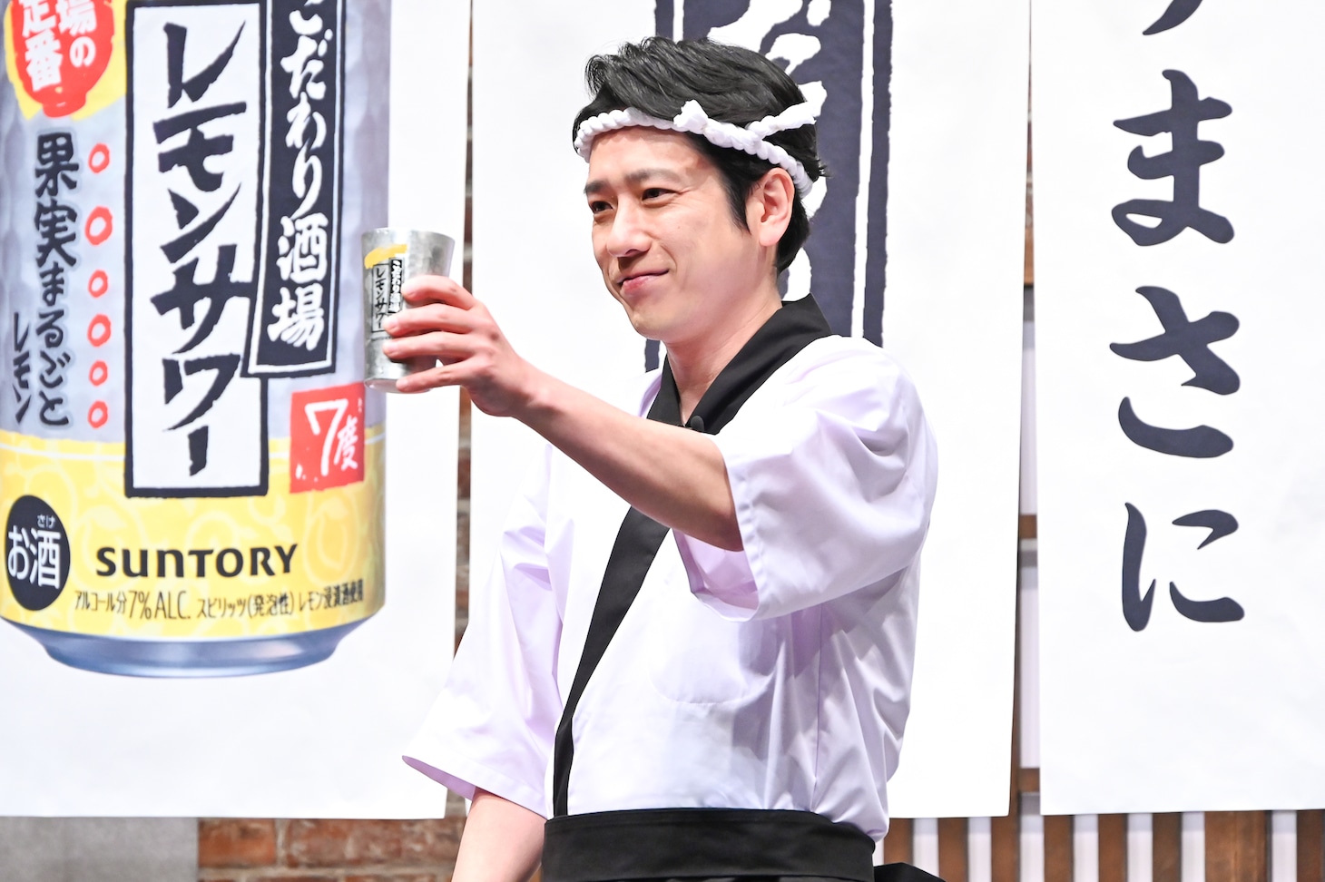 タンブラーを持ってカメラマンにアピールする二宮和也。