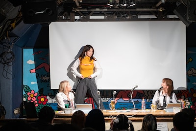 スクリーンの裏で生着替えをしてデビュー当時の衣装を披露する柴田あゆみ（中央）。