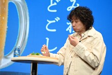 おつまみを試食する斉藤和義。