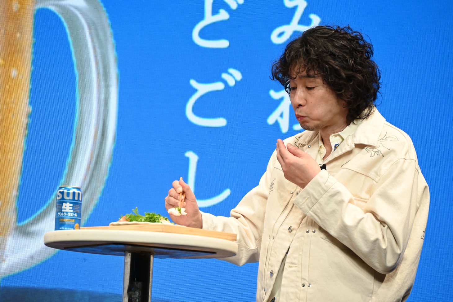 おつまみを試食する斉藤和義。