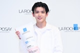 ラロッシュポゼの巨大ボトルを手にほほえむ長尾謙杜。