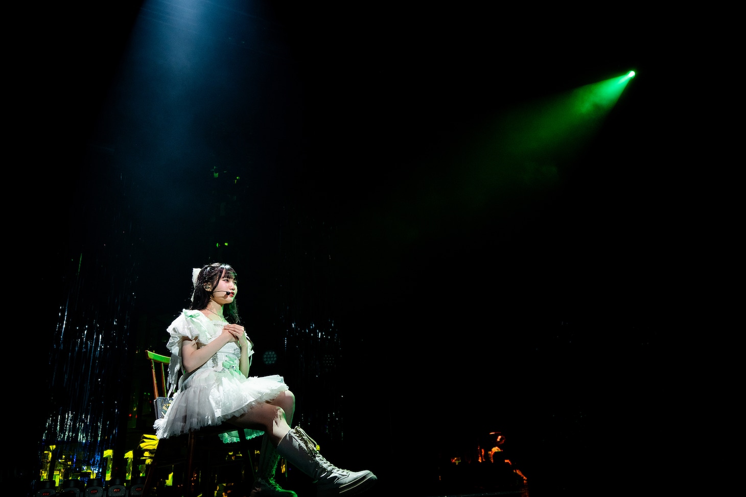 椅子に腰掛けて歌う吉瀬真珠。