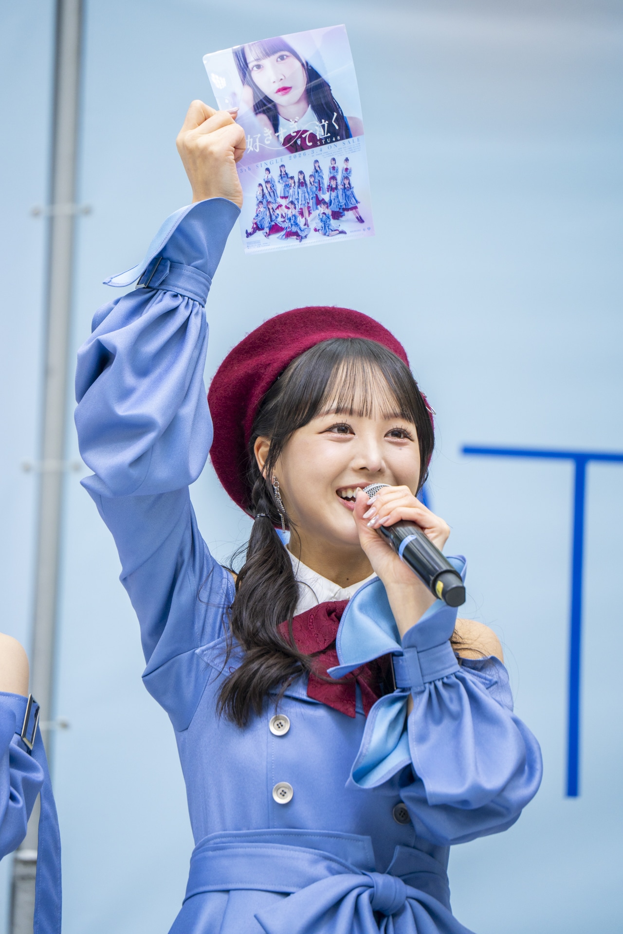 今回のイベントで無料配布されたクリアファイルを掲げる福田朱里。