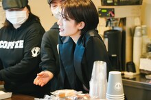 コーヒー店で接客するmikina（ExWHYZ）。