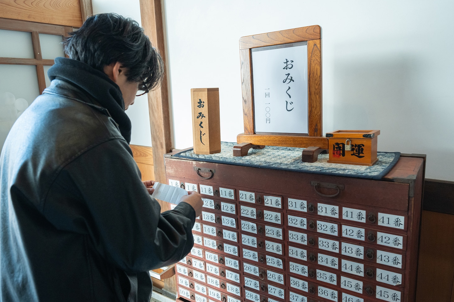 おみくじに書かれたお告げを確認する後藤正文。