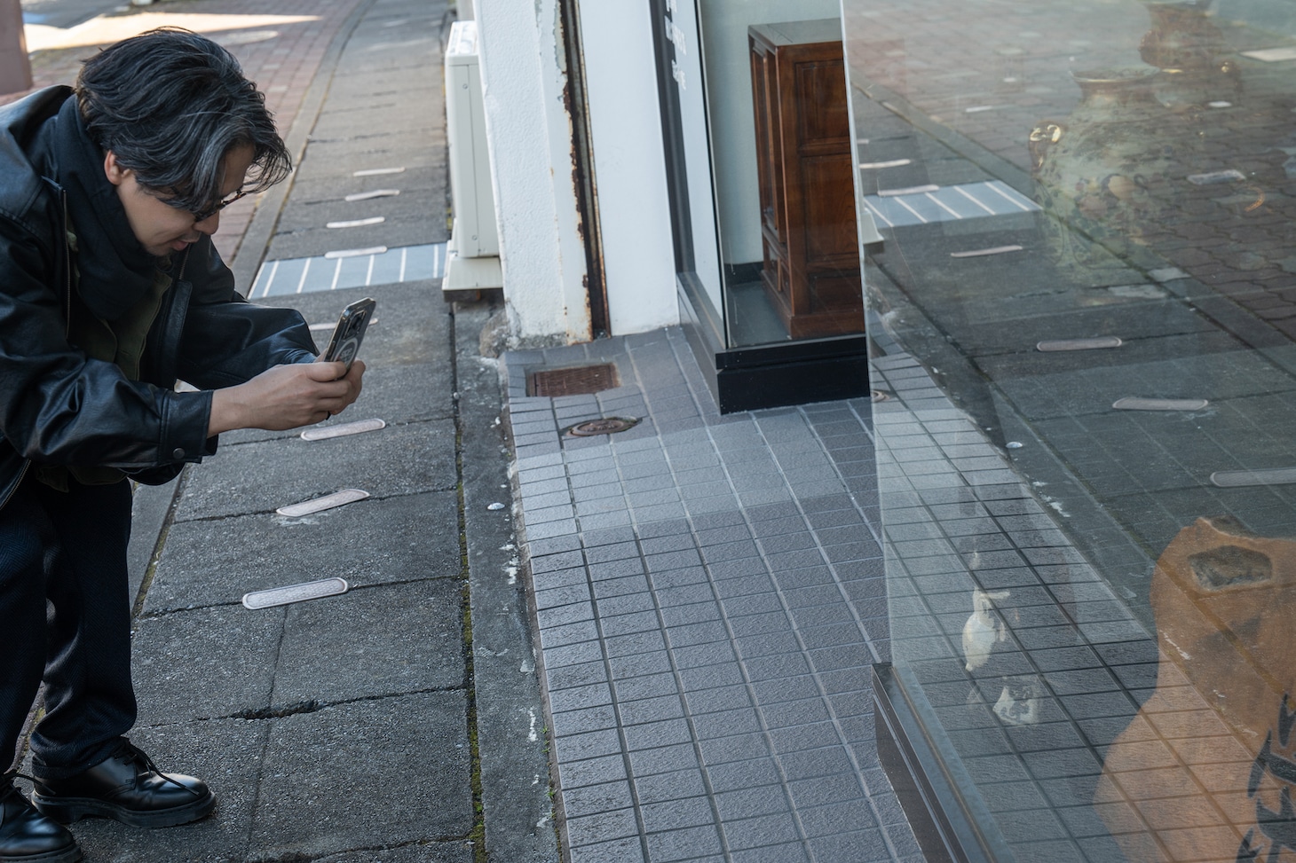 信楽焼（？）のたぬきを撮影する後藤正文。