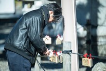 おみくじを結ぶ後藤正文。