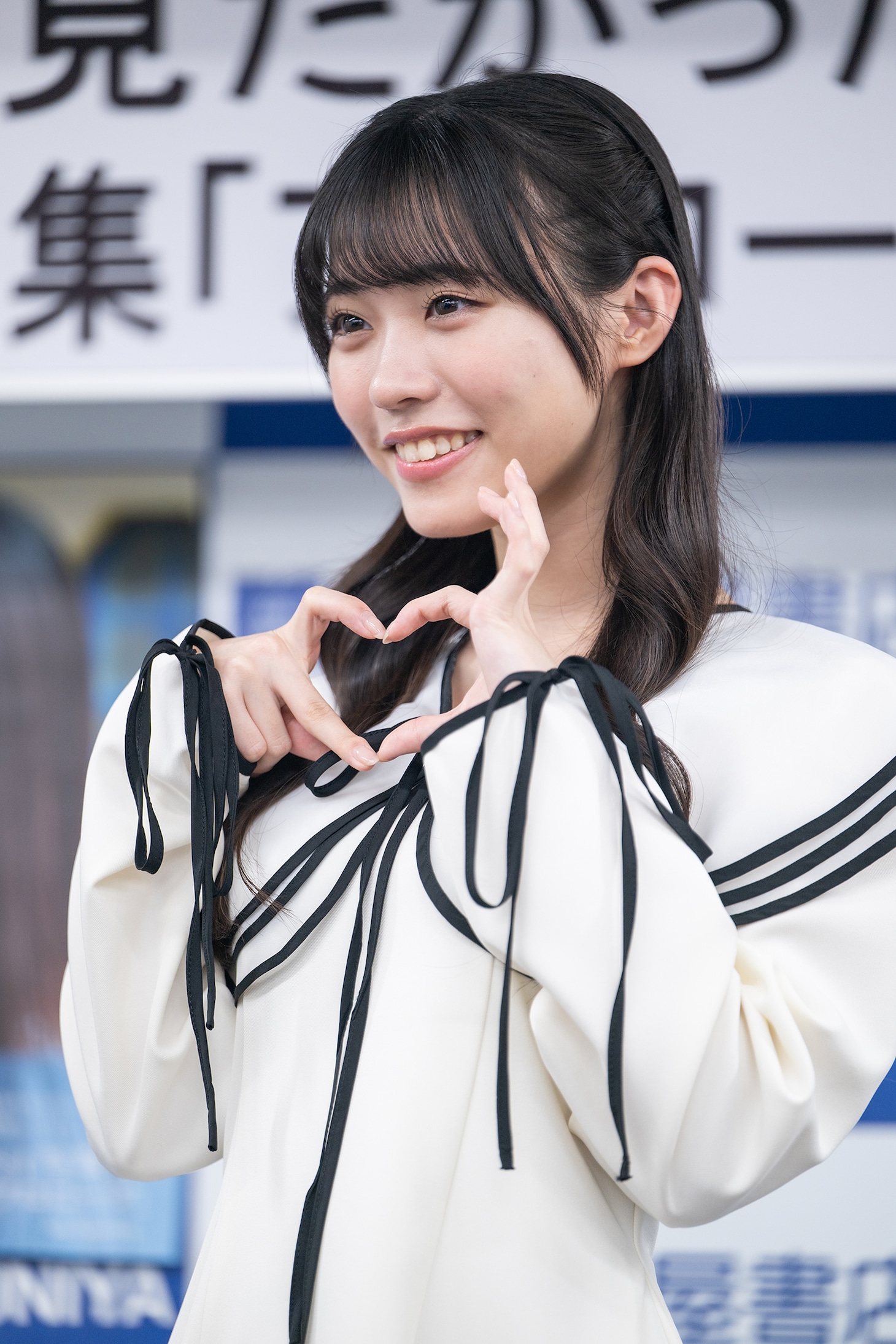 自身がセンターを務める楽曲「あれはフェアリー」の“フェアリーハート”ポーズを決める金澤亜美。