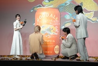 巨大な「キリングッドエール」缶パネルにサインを入れるMrs. GREEN APPLEとそれを撮影する浜辺美波。