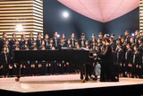 中学校の合唱部員86人と「手紙 ～拝啓 十五の君へ～」を歌唱するアンジェラ・アキ。©︎NHK