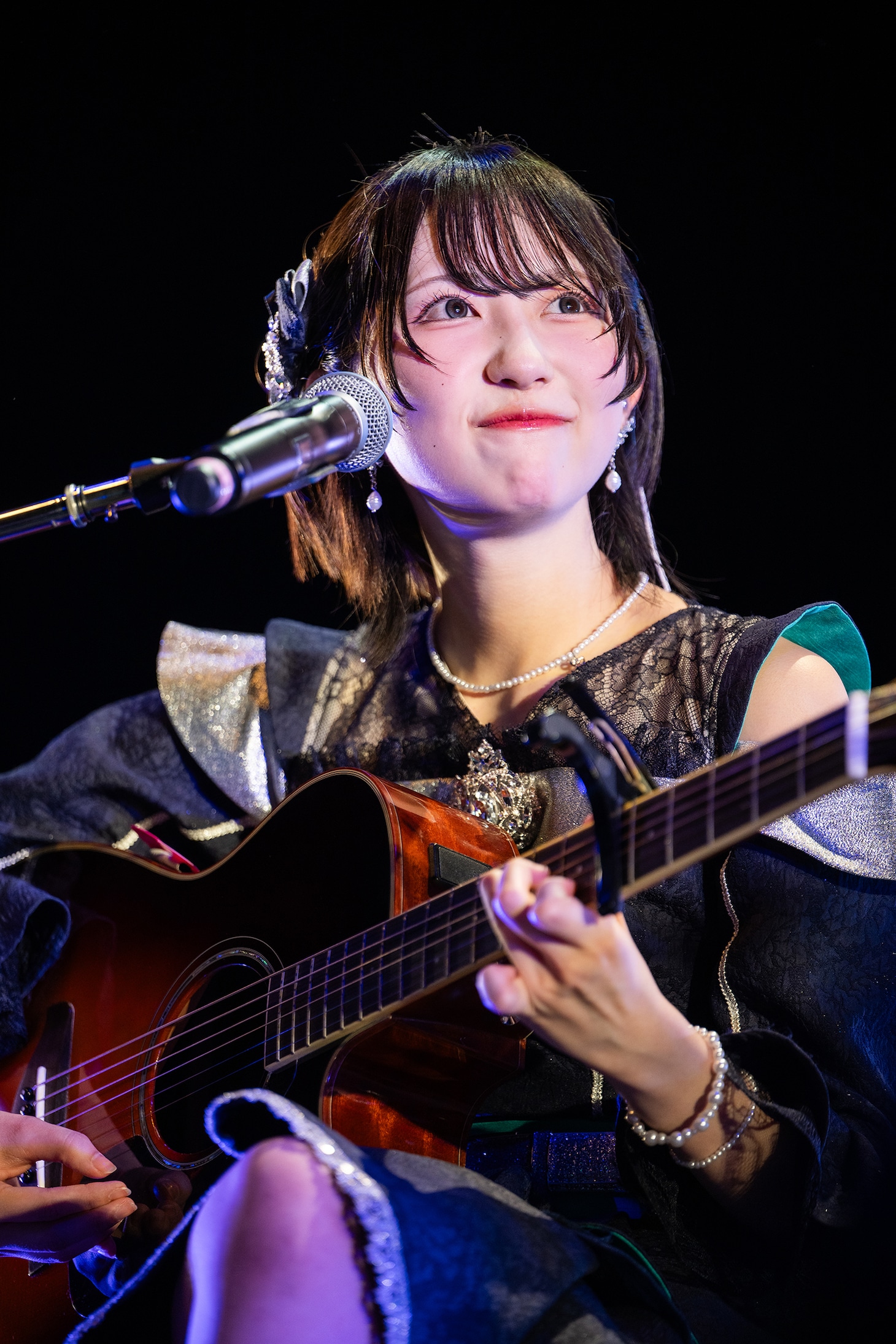ギターの弾き語りを披露する永松波留。