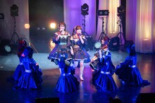 永松波留（左）に手を引かれステージ中央に立つ吉村萌南（右）。