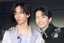 大好きなリョウガ（超特急 / 左）の肩を抱き、うれしそうにウィンクする高岡ミロ（Lienel / 右）。
