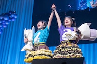 手をつないでステージを去る大和明桜（左）と蛭田愛梨（右）。