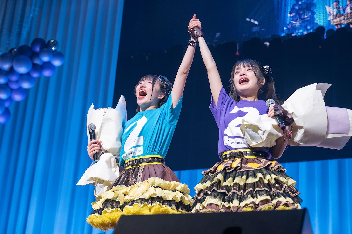 手をつないでステージを去る大和明桜（左）と蛭田愛梨（右）。