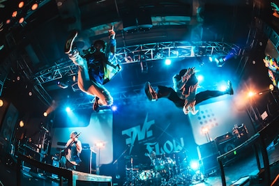 高くジャンプするKEIGO（Vo / FLOW）とKOHSHI（Vo / FLOW）。（撮影：オカベメイ）