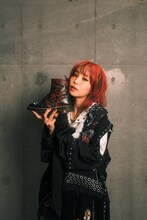 Dr. Martensのブーツを手にするLiSA。