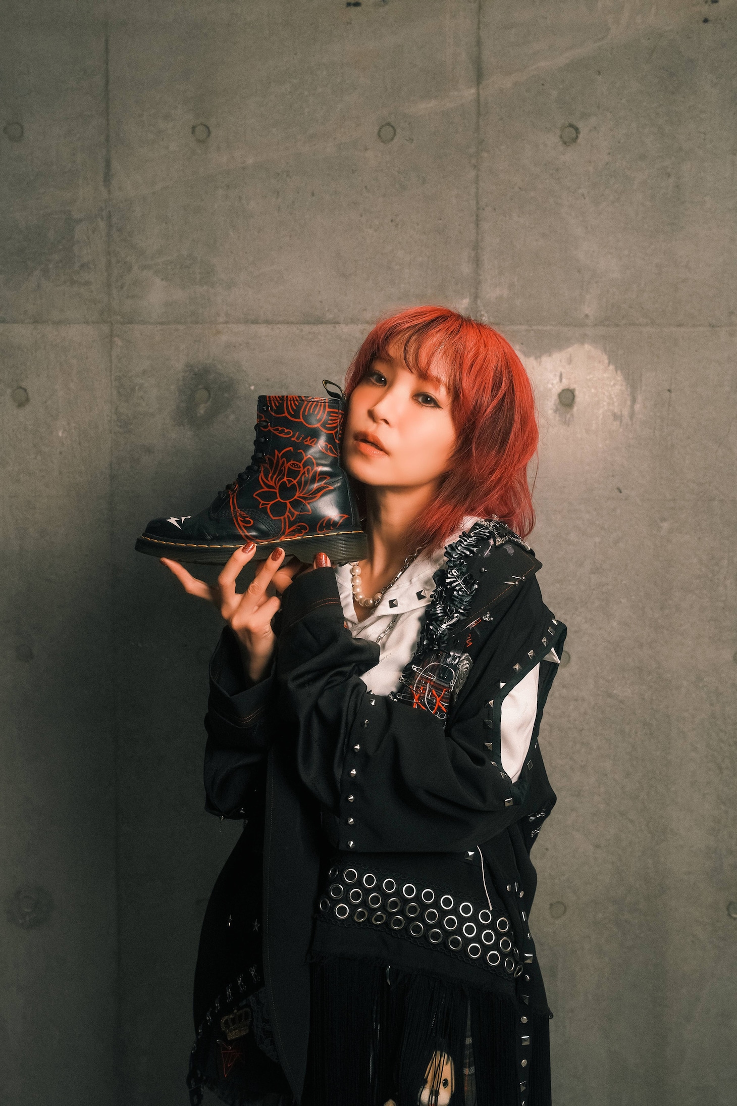 Dr. Martensのブーツを手にするLiSA。