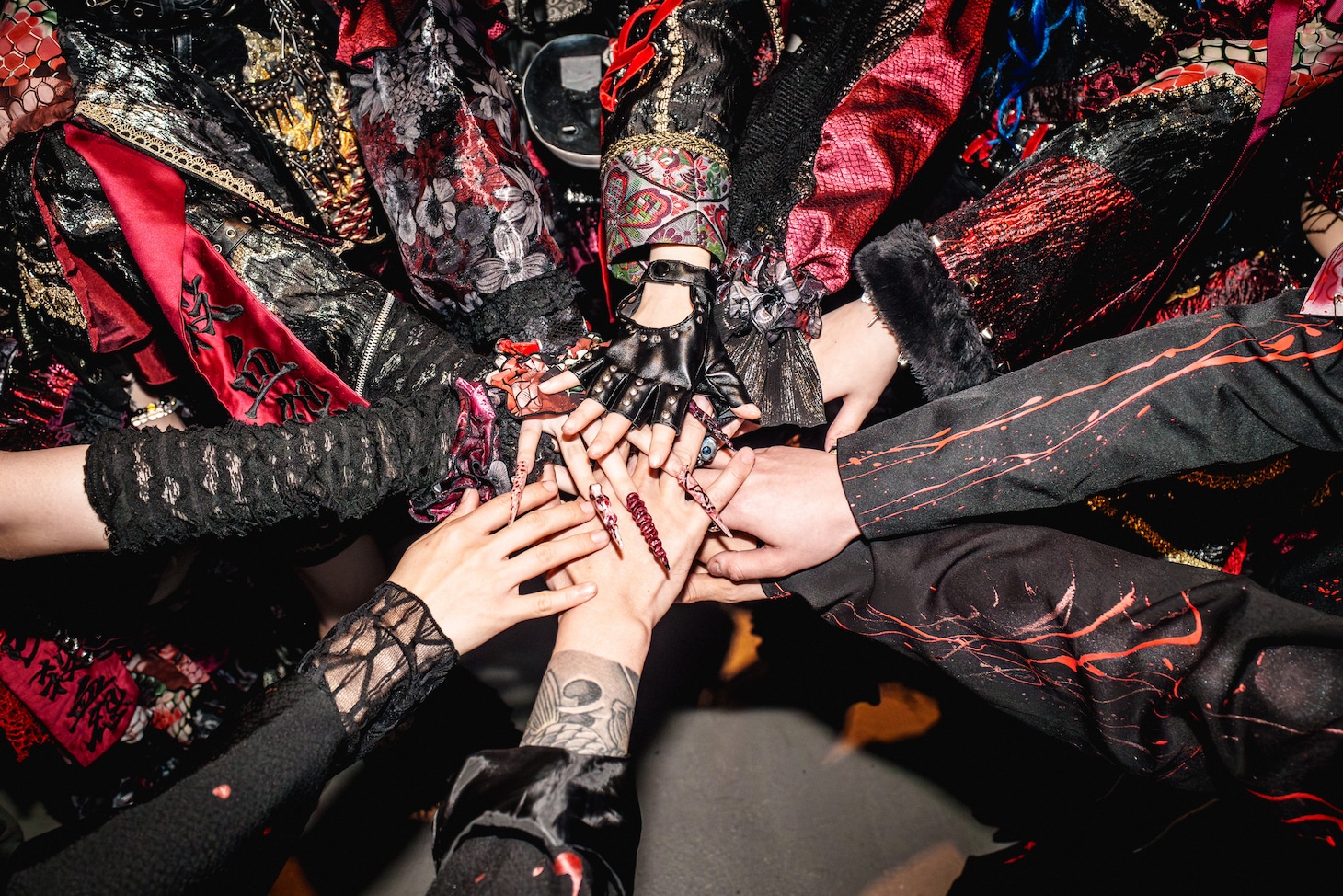 手を重ねるマザリとマザリバンドのメンバーたち。