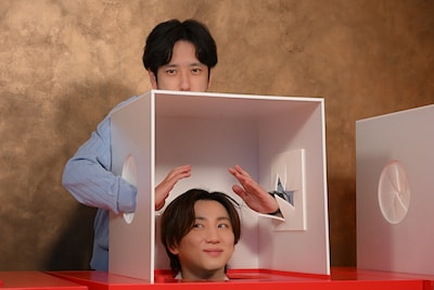 京本大我（SixTONES）の頭が中にある箱の中に両手を突っ込む二宮和也（嵐）。「6SixTONES」第3弾より。