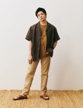 グラフィックTシャツにヨーロピアンリネン100％のブラウンシャツを着用する岸優太。
