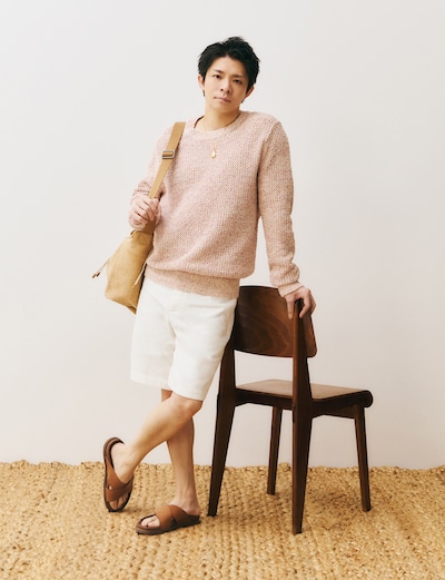 ピンクのニットにショートパンツを合わせる岸優太。