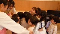 保育現場で子供と交流するMay J.。