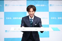特大名刺で「マネージャーさんとかを見て加わりたいなと思っていた」という名刺交換を再現してみせる阿部亮平（Snow Man）。