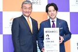 左から野村不動産ソリューションズの代表取締役社長・日比野勇志氏、“に野村和也”の巨大名刺を持つ二宮和也。