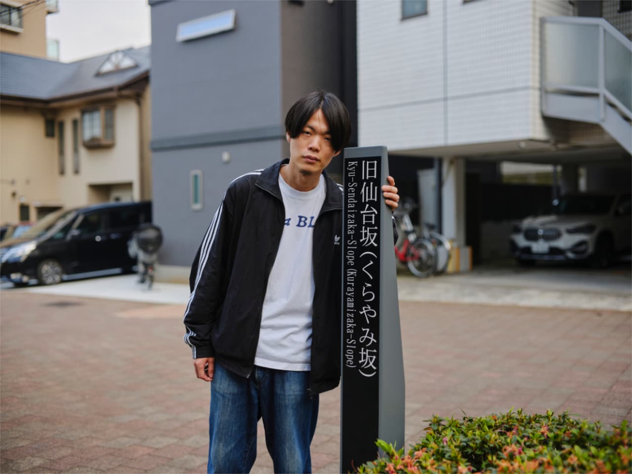 くらやみ坂の立て看板と清水正太郎。同様の看板が坂の麓にも。