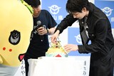 ふなっしーにケーキを取り分ける豆原一成（右）。