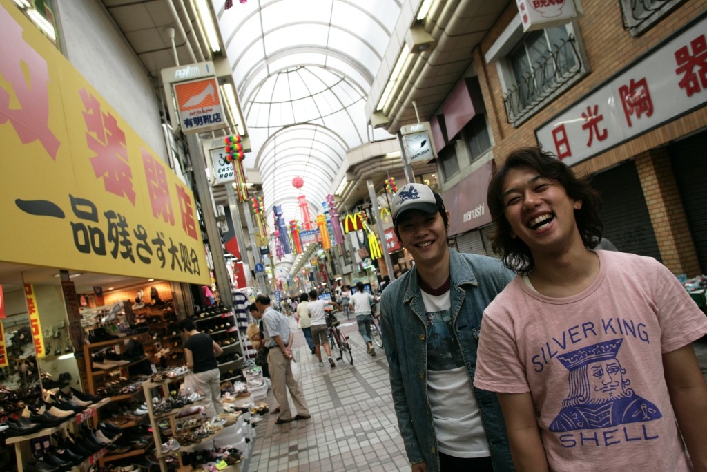 写真はイメージ。上京5年目に武蔵小山で撮った1枚。1年目の写真に比べ、すっかり東京になじんでいる井本と、笑いながらもまだ帽子をやや目深にかぶる藤原。