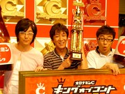 バッファロー吾郎から受け継いだ優勝トロフィーを掲げる飯塚。