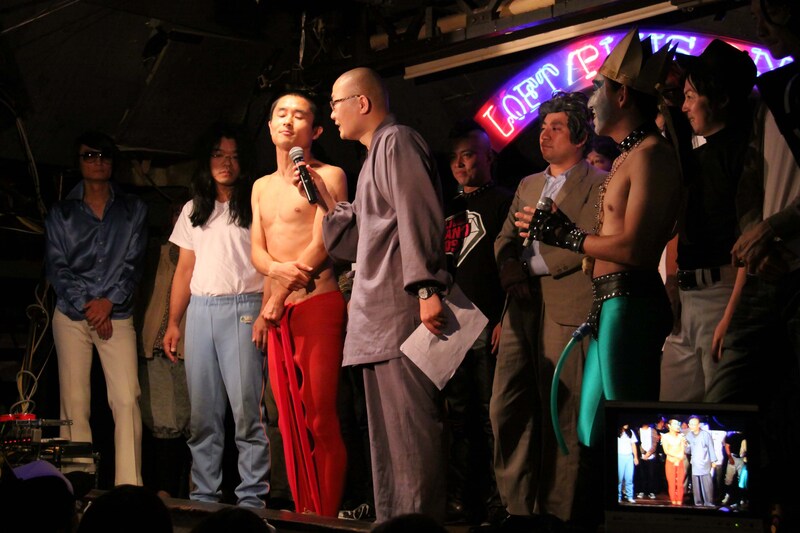 「世界キワモノ演芸2009」の優勝会見。司会のパンツ佐藤から優勝インタビューをうけるBコースハブ。　(c)フォトプロ