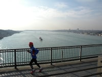 ボスポラス海峡にかかる橋を走る寛平。写真右にある大陸がヨーロッパ、左にある大陸がアジアとなっている。(c)間寛平アースマラソン製作委員会