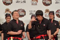 吉田が食べる姿を見て「汚すぎるやろ！」と爆笑する小杉。後ろのガリットチュウ熊谷の目にも注目。ちなみに吉田は普段お好み焼きは箸で食べるとのこと。