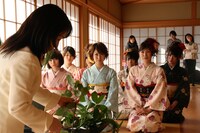 生け花の先生の話を熱心に聞く面々。(c)吉本興業