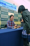 1人1人会話を交わしながら丁寧にサインしていく福田。