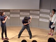 チーモンの2人は松尾を困らせようと、呼ばれてもなかなか舞台に登場せず、入口の扉を開かないように押さえていた。