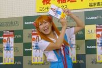 書籍「桜・稲垣早希のブログ旅 完全補完計画～関西縦断＆四国一周編～」を持ってはしゃぐ稲垣。