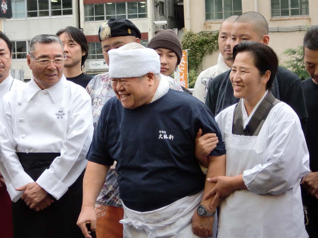 狩野とてつじのやりとりをほほえましく眺める大勝軒の山岸一雄。