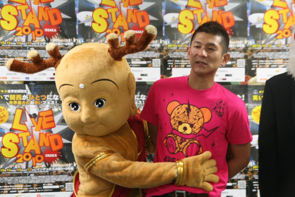 せんとくんの抱擁になぜかひきつる哲夫。(c)吉本興業