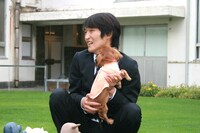 犬に顔をなめられるジュニア。