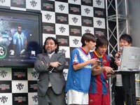 森本と岡部による対戦の様子。画面を熱く見つめるマラドーナ。