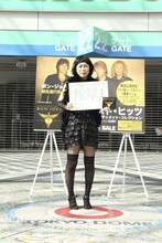 「BON JOVI宣伝応援隊長」任命状とBON JOVIベストアルバム「グレイテスト・ヒッツ」を手にする椿鬼奴。