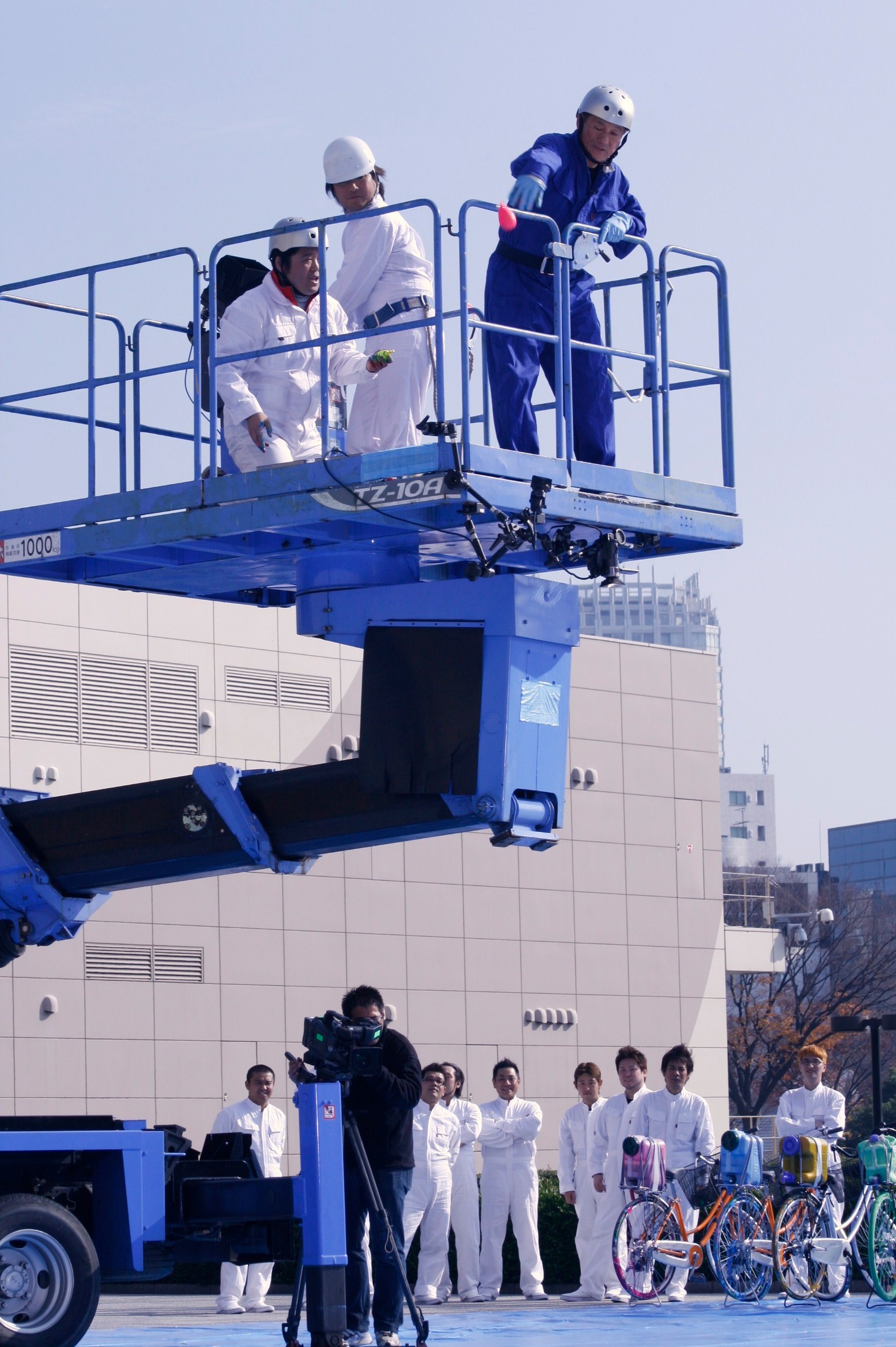 3メートルのクレーンからアクリル絵の具入り風船をキャンバスへ投げつけ、彩りを加えたたけし。