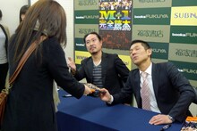 ファンにサイン本を受け渡す笑い飯。